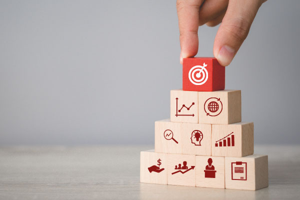 One hand piling wooden cubes with positive prints on them | Ethical Practices in Mortgage Brokering | DG Pinnacle TPO - Miami Wholesale Mortgage Funding Lender