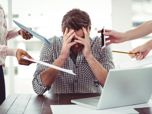 Stressed out man at the office | 5 Ways to Avoid Burnout as a Loan Officer | DG Pinnacle TPO - Wholesale Division | Miami Mortgage Lender