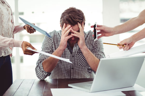 Stressed out man at the office | 5 Ways to Avoid Burnout as a Loan Officer | DG Pinnacle TPO - Wholesale Division | Miami Mortgage Lender