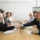 Group of people having a meeting and two of them shaking hands over the desk | MBA urges federal rollback of mortgage rules | DG Pinnacle TPO - Wholesale Division | Miami Mortgage Lender