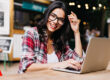 Beautiful freelancer woman smiling next to her laptop | DG Pinnacle TPO - Miami Wholesale Mortgage Funding Lender