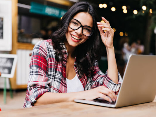 Beautiful freelancer woman smiling next to her laptop | DG Pinnacle TPO - Miami Wholesale Mortgage Funding Lender